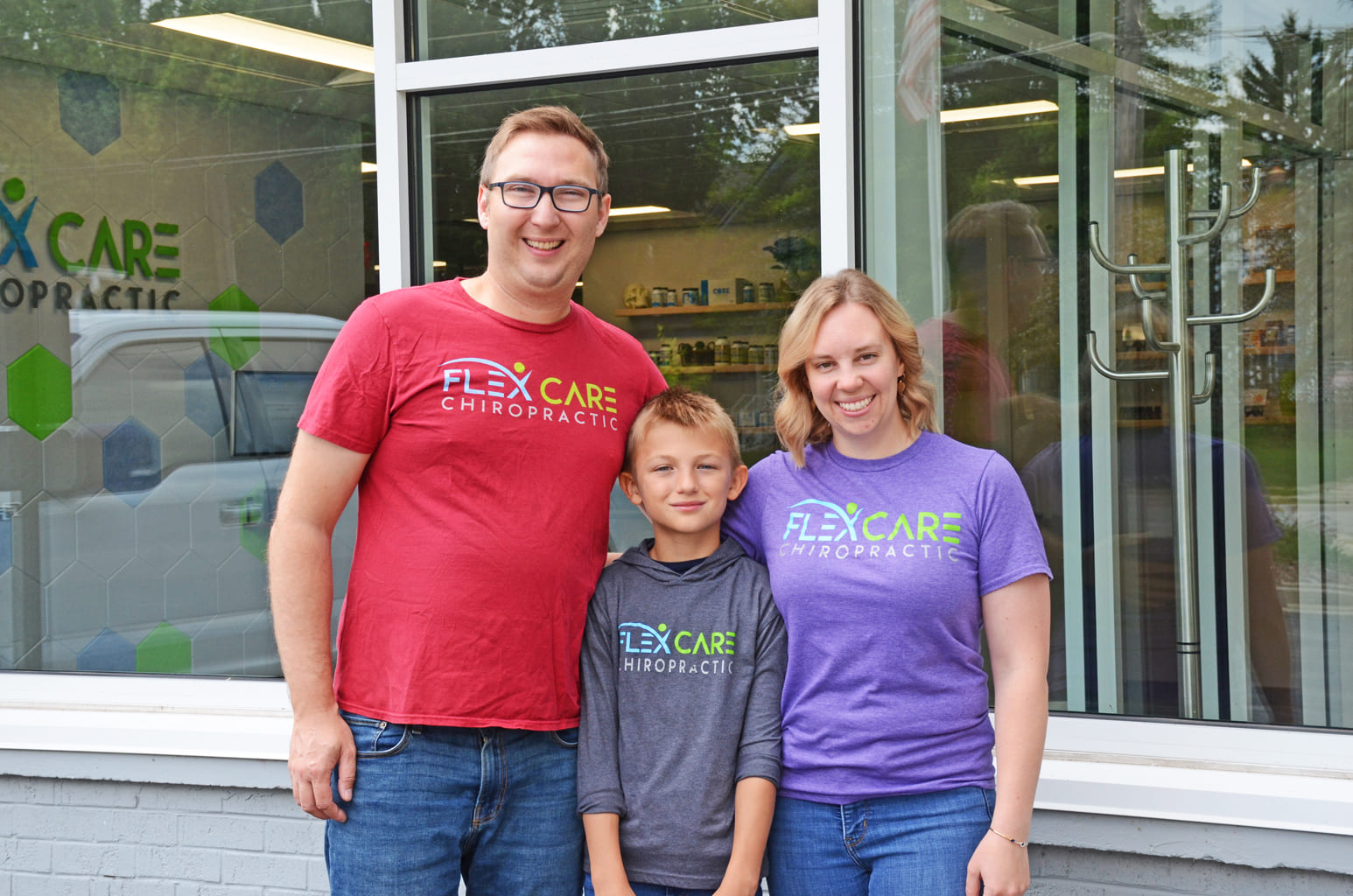 Dr. Zach Chudy with his family outside Flex Care Chiropractic in Oconomowoc